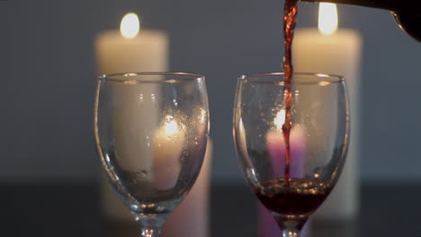 Zwei-Gläser-Rotwein-Werden-Am-Kerzenbeleuchteten-Esstisch-Eingegossen