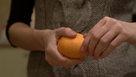 Mujer-Pelando-Una-Naranja,-Mandarina-Cerca-De-Tiro-De-Manos