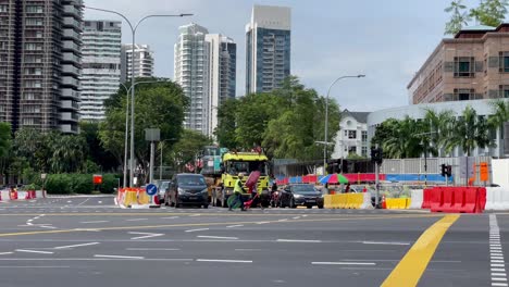 Arbeiter-Mit-Gelber-Weste,-Der-Ein-Verkehrsschild-Trägt,-Das-Die-Straße-überquert,-Novene,-Singapur