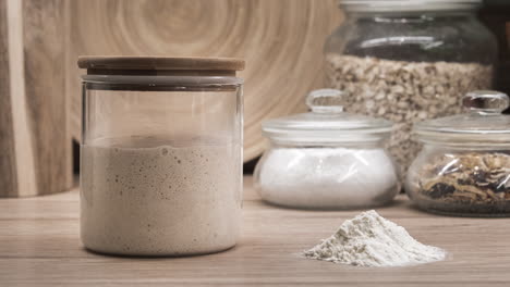 Bubbly-Sourdough-Starter-Proofing-In-A-Glass-Jar-At-The-Kitchen---zoom-out-shot,-timelapse