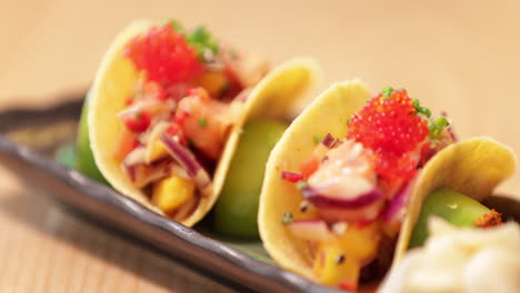 Sushi-Colorido-En-Tacos-Crujientes-En-Un-Plato-Rectangular---Sartén-A-Cámara-Lenta-A-La-Derecha