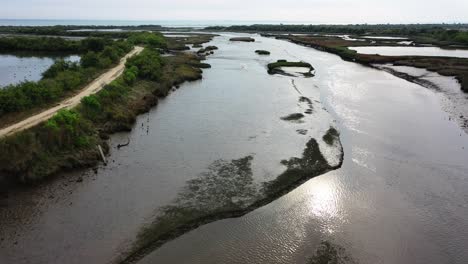 Wetland-river-merging-with-Arcachon-Bay-waters-at-the-Domaine-de-Graveyron-area-in-western-France,-Aerial-flyover-view