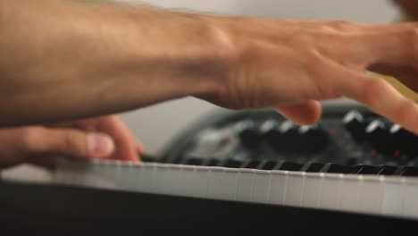 Close-up-of-a-professional-piano-players-and-stage-pianos-keys-while-playing-chords-during-a-recording-session-with-a-bright-background