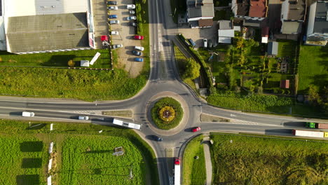 Vehicles-In-Slow-Motion-At-Roundabout-In-Lubawa,-Poland-On-A-Sunny-Morning---aerial-top-down