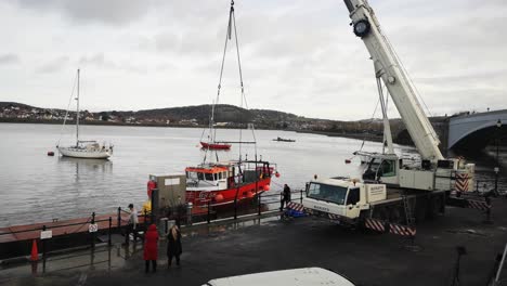 Telescopic-crane-vehicle-lifting-fishing-boat-on-Conwy-Wales-harbour
