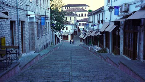 Alley-with-cobblestones-and-traditional-buildings-at-morning-in-Gjirokaster,-Albania