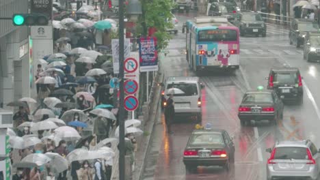 Menschenmenge-Mit-Regenschirmen,-Die-An-Regnerischen-Tagen-Auf-Der-Bürgersteigstraße-In-Der-Nähe-Der-Shibuya-Kreuzung-In-Tokio,-Japan,-Spazieren-Gehen