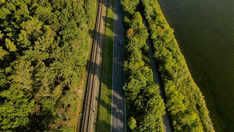 Flying-over-highway-road-and-railway-in-Kuznica-tourist-spot-in-Hel-Peninsula,-Poland,-baltic-sea,-Slow-aerial-flying-straight-forward-movement