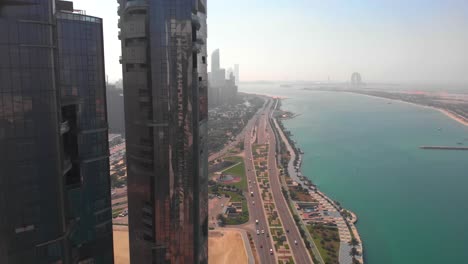 Aufsteigende-Luftaufnahme-Einer-Großen-Autobahn-In-Abu-Dhabi-In-Der-Nähe-Der-Wolkenkratzer