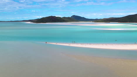 Rotating-drone-shot-of-people-on-beautiful-sandy-beach-at-Whitehaven-Beach-Whitsunday-Island-Australia