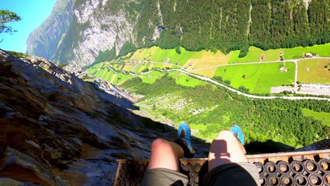 At-an-altitude-of-800m,-a-man-is-sitting-on-a-platform-for-base-jumpers