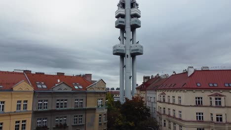 Prague-Zizkov-Tower-aerial-drone-ascending-view-from-street-between-houses,-capital-of-Czech-Republic
