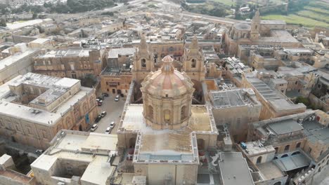 4k-aerial-drone-footage,-circling-around-St-Paul's-Cathedral-in-the-stone-fortified-walled-city-of-Mdina-of-the-Northern-Region-of-Malta