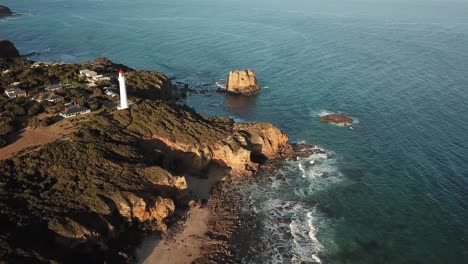 Drone-aerial-during-the-sunset-over-the-aireys-inlet-lighthouse-on-the-cliffside-Great-Ocean-Road