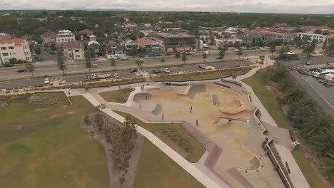Drone-aerial-over-St-Kilda-skate-park-with-skateboarders-riding-and-falling-in-the-bowl
