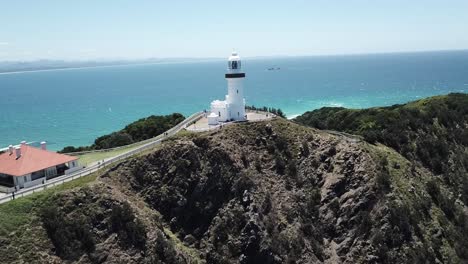 Drone-aerial-zoom-in-to-lighthouse-by-a-beautiful-blue-ocean-in-summer