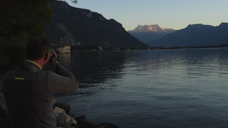 middle-aged-man-photographs-the-castle-of-Chillon-in-Switzerland-and-during-the-golden-hour