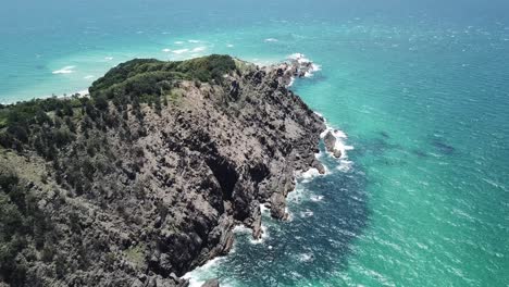 Drone-aerial-over-crystal-clear-beautiful-blue-water-on-cliffsedge-in-summer
