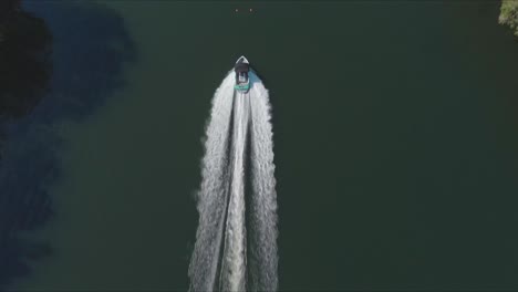 Tracking-a-water-ski-boat-from-above,-aerial-shot