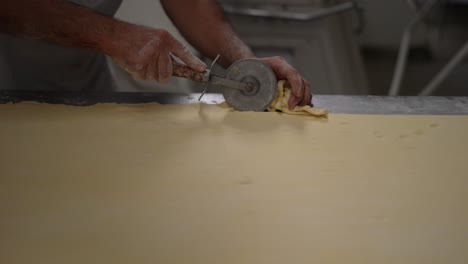 baker's-hands,-artisan-bakery,-baker-making-bread-and-pastry,-dough-kneading,-wheel-cutter