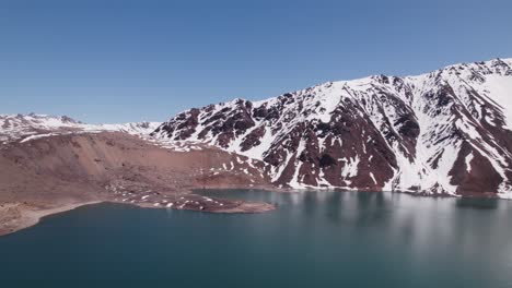 Ruhiges-Blaues-Wasser-Des-El-Yeso-Damms,-Umgeben-Von-Schneebedeckten-Bergen-In-Chile