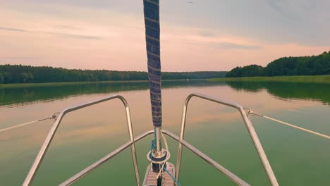 sailing-boat-floats-in-the-calm-sea-at-sunrise