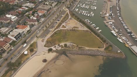Drone-aerial-over-St-Kilda-skate-park-and-sandy-beach-with-boats-in-the-boat-yard