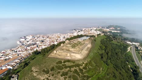 Aerial-panning-shot-of-medina-sidonia-with-a-view-over-the-castillo-de-medina,the-church-of-santa-maria-and-the-old-town-with-beautiful-white-buildings-on-a-beautiful-day