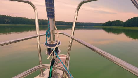 sailing-boat-floats-in-the-calm-sea-at-sunrise