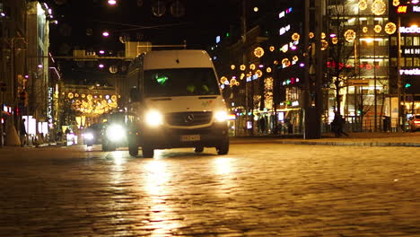 Autos-Fahren-Auf-Gepflasterten-Straßen,-Die-Nachts-In-Helsinki-Finnland-Mit-Weihnachtslichtern-Geschmückt-Sind