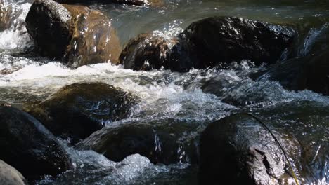 Wasser,-Das-Durch-Felsen-Fließt,-Macht-Wassergeräusche-Und-Weiße-Wasserblasen