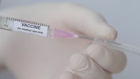 Hand-Removing-Cap-Of-Syringe-Needle---Vaccine-for-Medical-Use-Only---close-up,-slow-motion