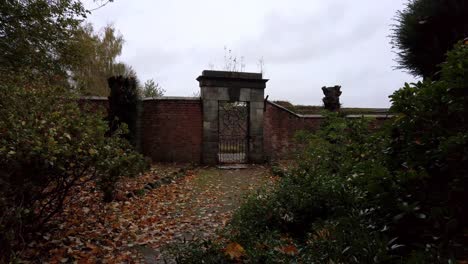 Static-shot-of-old-stone-wall-garden-and-historic-gate