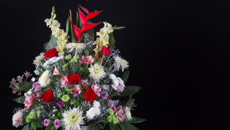 Funeral-flower-arrangement-slider-panning-wide-shot-black-background