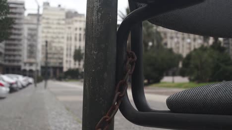 Close-up-of-chair-with-chain-on-pole-in-Plaza-Independencia,-Montevideo