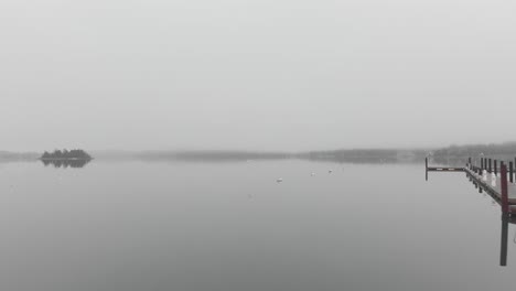 Seagull-flying-over-calm-foggy-harbor-in-a-day-time