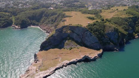 Aerial-fly-over-famous-Long-quarry-view-point-surrounded-by-Atlantic-ocean-and-Torquay-City-in-background