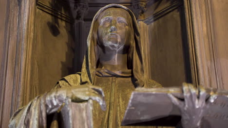 Statue-Einer-Kapuzenfigur-Mit-Buch,-Erhobenem-Arm,-Nische,-Nachts,-Prag,-Tschechien