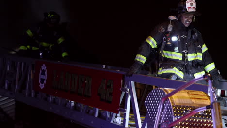 A-Fireman-Descends-a-Ladder-in-Full-Gear-After-Fighting-a-House-Fire-at-Night
