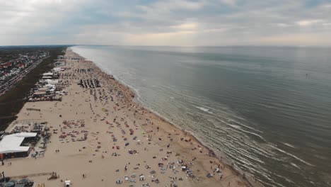 Aerial-footage-of-a-crowded-beach-along-a-North-Sea-resort-near-Zandoort,-Netherlands