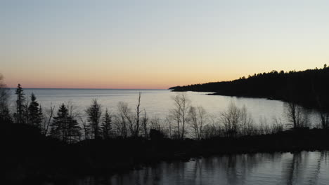 Aerial-view-of-peninsula-reveals-Lake-Superior-shoreline-at-sunset---drone-reveal-shot