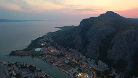 Amazing-sunset-over-Croatian-coastal-town-Omis,-mountain-backdrop,-aerial-view