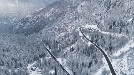 Aerial-View-Of-Road-In-Remote-Mountain-Range-In-Winter-Landscape-At-American-Fork-Canyon,-Wasatch-Mountains-Of-Utah,-USA