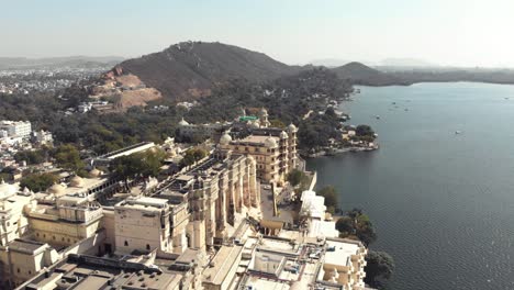 4k-aerial-drone-footage-of-the-lakeshore-Shiv-Temple-in-the-city-of-Udaipur,-India-just-off-of-Lake-Pichola