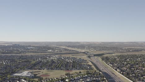 aerial-flyover-sunrise-highways-freeways-intersection-passages-overpasses-inbetween-commuter-traffic-headed-out-of-rows-of-residential-communities-schools-at-the-South-East-region-of-Calgary-AB-1-2