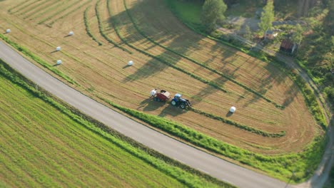 Eine-Luftaufnahme-Des-Traktors,-Der-Gras-Erntet-Und-Es-In-Ordentliche-Weiße-Plastikrollen-Verpackt