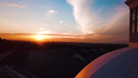 Beautiful-4K-Aerial-Drone-shot-zooming-into-sunset-with-White-House-styled-building-in-shot-in-Sandhurst,-Sandton