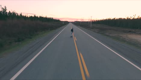 Un-Joven-Patina-En-Medio-De-Una-Carretera-Secundaria-En-Canadá