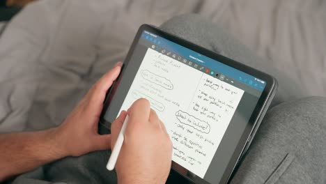 Close-up-of-content-creator,-student-or-freelancer-taking-notes-and-planning-digitally-on-iPad-tablet,-sitting-at-home,-using-tablet,-doing-homework,-taking-notes,-planning,-work,-analyzing