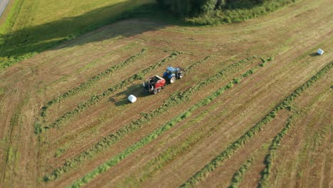 Der-Traktor-Bewegt-Sich-Langsam,-Sammelt-Gras-Und-Verpackt-Es-In-Ordentliche-Weiße-Plastikrollen